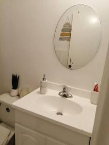 a bathroom with a white sink and a mirror at Eastside Homes in Heart Ease