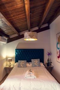 1 dormitorio con 1 cama grande y cabecero azul en Apartamentos en el Valle del Jerte Flores para Angela en Cabezuela del Valle