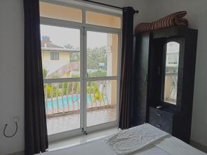 a bedroom with a window with a view of a pool at Zalor Residency 2 in Varca