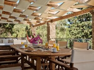 uma sala de jantar exterior com uma mesa de madeira e cadeiras em Villa Zakynthos em Skinária