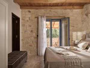 a bedroom with a bed and a stone wall at Villa Zakynthos in Skinária