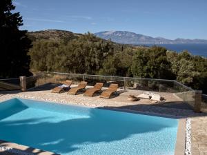 una piscina con sedie e vista sull'acqua di Villa Zakynthos a Skinária