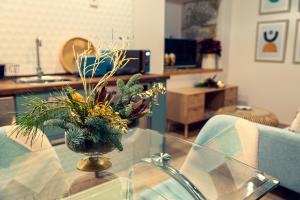 un jarrón de flores sobre una mesa de cristal en la sala de estar en Apartamentos en el Valle del Jerte Flores para Angela, en Cabezuela del Valle