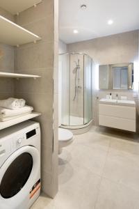 a bathroom with a washing machine and a toilet at Riverside Design Apartment with underground private parking in Rīga
