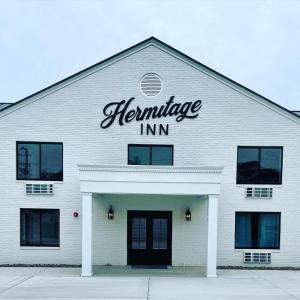 a white building with a sign on top of it at The Hermitage Inn and Taphouse in Petersburg