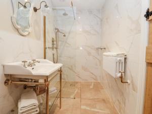 a white bathroom with a sink and a shower at Abbey Green Farm in Wem