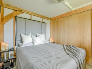 a bedroom with a large bed with white pillows at Elm Retreat in Upper Hardres