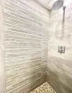 La salle de bains est pourvue d'une douche et d'un mur en bois. dans l'établissement Trouville Plage Casino, à Trouville-sur-Mer