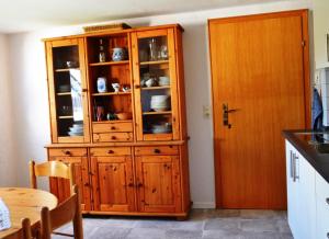 a wooden cabinet in a kitchen next to a table at Frankenau Fewo Kellerwald in Frankenau