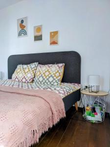 a bedroom with a bed with a pink blanket and a table at Honey I`m home Apartments in Veliko Tŭrnovo