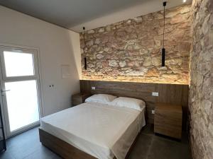 a bedroom with a bed and a stone wall at Al Piano Terra in Ancona