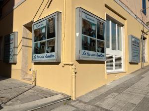 a yellow building with two windows on a street at Al Piano Terra in Ancona