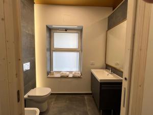 bagno con servizi igienici, lavandino e finestra di Al Piano Terra ad Ancona