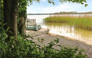 a boat on a dock next to a body of water at Holiday Home Morag Kretowiny Iii in Pojezierce