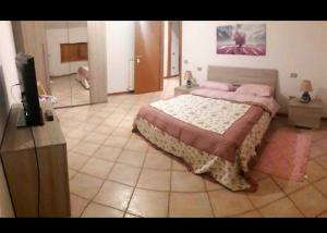 Schlafzimmer mit einem Bett und einem Flachbild-TV in der Unterkunft B&B VIA ROMA N. 12 in Valfabbrica