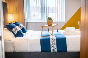 a hotel room with a bed with a table on it at Spacious 1-Bedroom Home with free private parking in Swansea