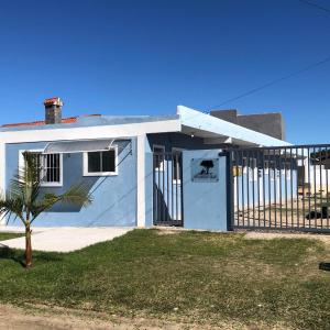 a blue house with a gate in front of it at Pousada Patriarca Silva in Rio Grande
