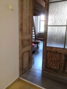 a hallway with an open wooden door and a staircase at Szeged-Vár in Szeged