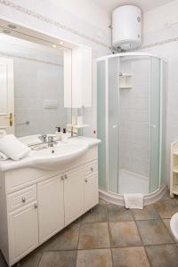 a white bathroom with a shower and a sink at Residence Sole Dell'Argentario in Porto Santo Stefano +102 photos