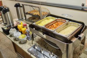 a kitchen counter with some food on top of it at Ibituruna Center Hotel in Governador Valadares
