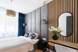 een slaapkamer met een bed en een grote spiegel bij KOBIELA Luxury Aparthotel KTW City Center in Katowice