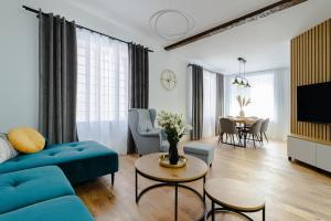 a living room with a blue couch and a table at KOBIELA Luxury Aparthotel KTW City Center in Katowice