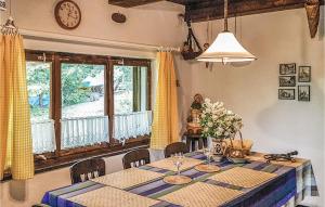 a dining room with a table and a clock on the wall at Beautiful Home In Barczewo With 2 Bedrooms in Barczewo