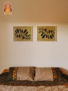 - une chambre avec 2 photos sur le mur et un lit dans l'établissement Apartman 8, à Valjevo