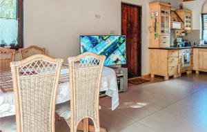 a dining room with a table and two wicker chairs at Amazing Home In Rybakowo With Kitchen in Rybakowo