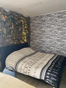 a bed in a room with a brick wall at Chambre avec spa privatif in Amiens
