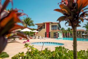 a resort with a swimming pool and a house at Duplex 3 suítes em Condomínio Jerusalém 1 in Porto Seguro