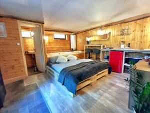 a bedroom with a bed and a kitchen at Tölgyes Menedék 2. in Noszvaj