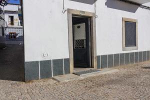 um edifício branco com uma porta ao lado em Apartamento Almirante T1 by YHA em Tavira