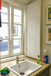 um lavatório branco numa cozinha com duas janelas em Apartamento Almirante T1 by YHA em Tavira