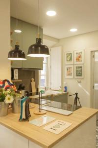 a kitchen with two black pendant lights over a counter at Apartamento Almirante T1 by YHA in Tavira