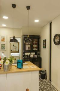 a kitchen with a counter and a clock on the wall at Apartamento Almirante T1 by YHA in Tavira