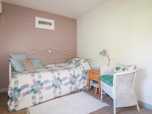 博德明的住宿－The Mews，一间卧室配有一张床、一把椅子和一张书桌