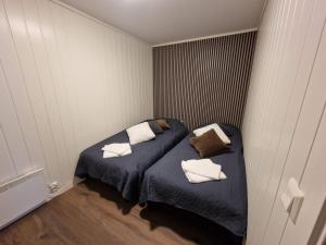 Piccola camera con letto e cuscini sopra di Nord Hus Service AS, Nr 1 a Havøysund