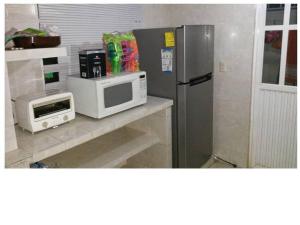 a kitchen with a microwave and a refrigerator at Casa en la zona de Acapulco diamante in La Sabana