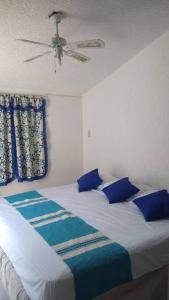 Casa en la zona de Acapulco diamante في La Sabana: غرفة نوم بسرير ومخدات زرقاء وسقف