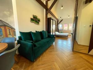 a living room with a green couch and a table at Long Attic Studio in Poznań