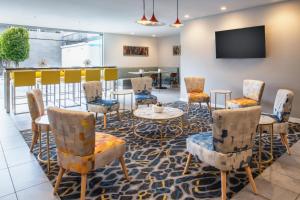 a lobby with chairs and tables and a bar at Hotel Lucent in Menlo Park