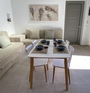 a living room with a table with chairs and a couch at Matala Prime Villas in Matala