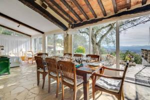 - une salle à manger avec une table, des chaises et des fenêtres dans l'établissement L'Olivette - Mas Provencal, Panoramic View & Pool, à Callian