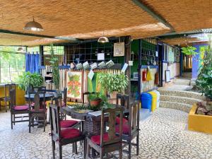 a restaurant with tables and chairs and plants in it at Montaña Linda Hostel Orosi in Orosí