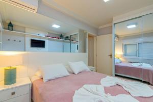 une petite chambre avec un lit et un miroir dans l'établissement Excelente no Centro de Canela @stayhousetemporada, à Canela