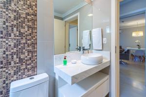 a bathroom with a sink and a mirror at Apartamento Helena - Stay House Temporada in Canela
