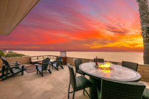 a patio with a table and chairs with a sunset at Newport Beach Front View I in Newport Beach