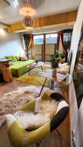 Polana Szymoszkowa Ski Resort - Chamerion Apartments في زاكوباني: غرفة معيشة مع أريكة وطاولة زجاجية