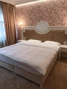 Cardinale Resort في ياش: غرفة نوم بسرير كبير ومرآة على الحائط